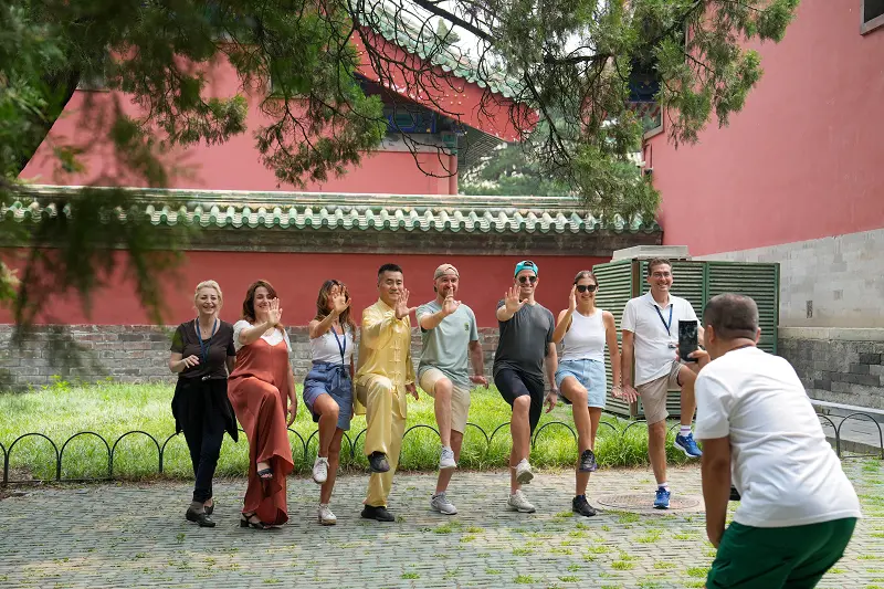 Tourists from Italy pose for a group photo after experiencing Tai Chi at the Temple of Heaven Park in Beijing