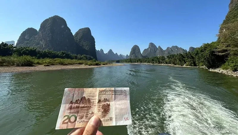 The iconic 20 RMB banknote view of Li River in Xingping, Guilin, featuring karst peaks and a cormorant fisherman on a bamboo raft at dawn.