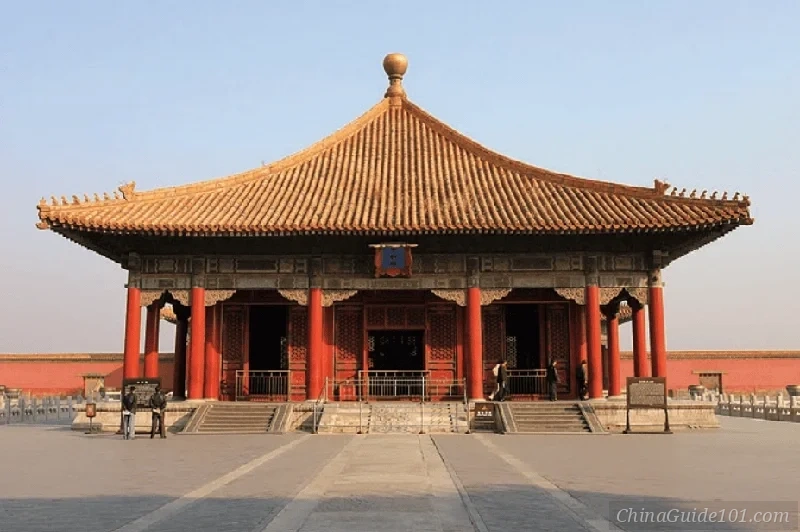 The Hall of Central Harmony at the Palace Museum in Beijing, displaying traditional Chinese imperial architecture with its iconic yellow-tiled pyramidal roof and crimson walls under a pale sky.