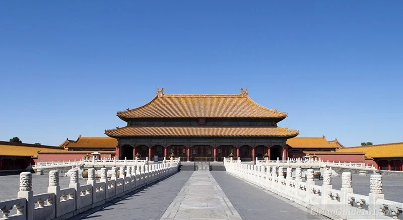 The front facade of the Palace of Heavenly Purity at the Palace Museum, Beijing, showcasing its iconic amber-yellow tiled roof and white marble terrace against a bright blue sky