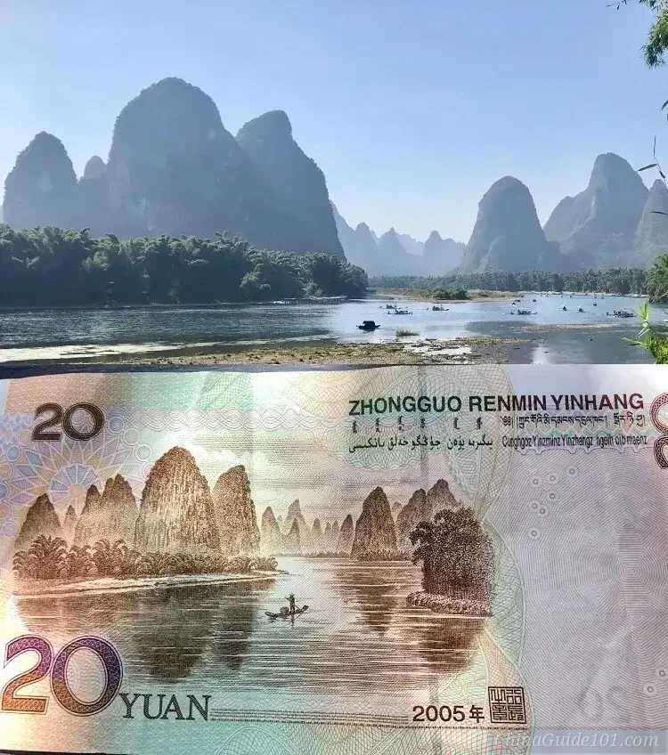 A photograph taken from the perspective of a traveler, holding a Chinese 20 Yuan banknote with a drawing of a landscape in the foreground, while a very similar, real-life view of the Li River and karst mountain peaks in Yangshuo serves as the background, demonstrating the banknote’s inspiration.