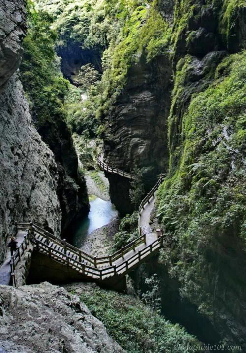 Wooden boardwalk and stone hiking path winding through Longshuixia Fissure Gorge, Wulong Karst near Chongqing, China