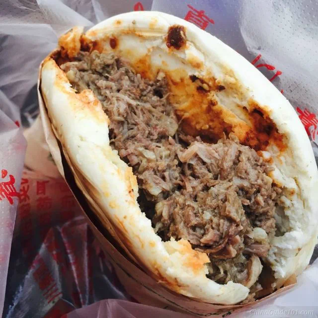 xian rou jia mo, chinese meat burger filled with slow-cooked shredded pork inside baked flatbread, famous shaanxi street food