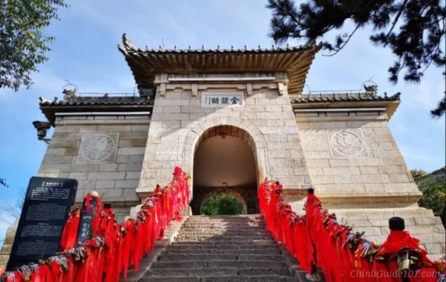 Stone gate of Golden Lock Pass on Huashan, lined with red prayer ribbons and love locks