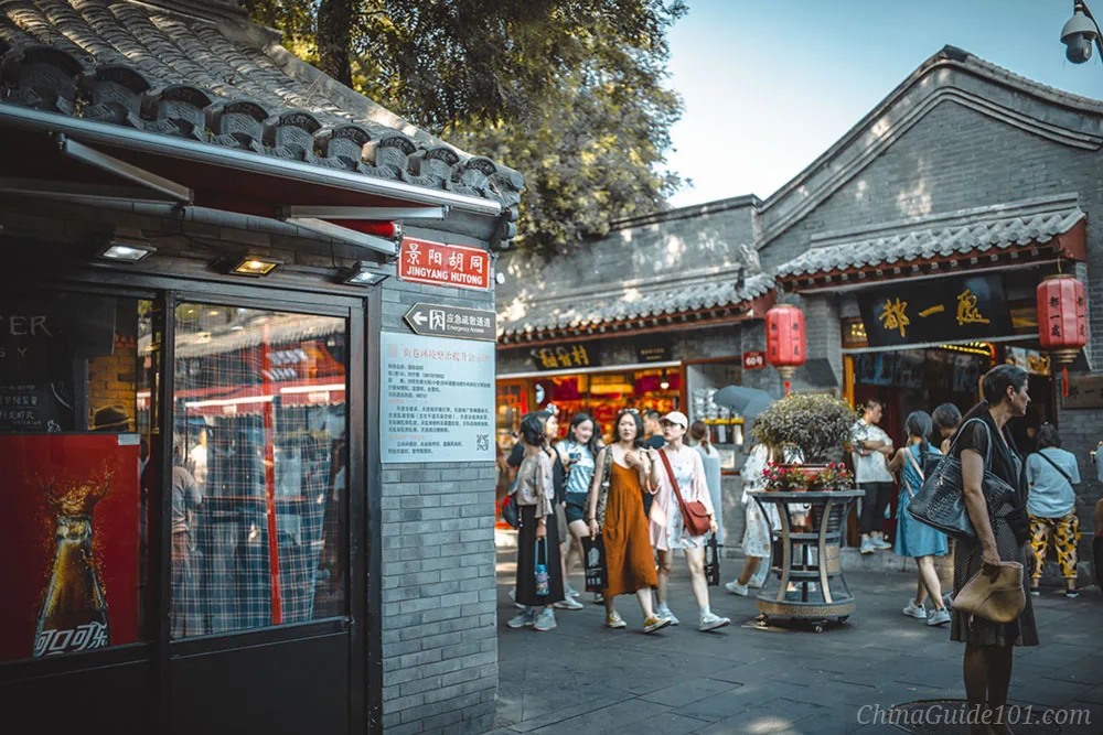 Jingyang Hutong on Nanluoguxiang, busy pedestrian street with traditional grey brick buildings, shops and sightseeing tourists in Beijing